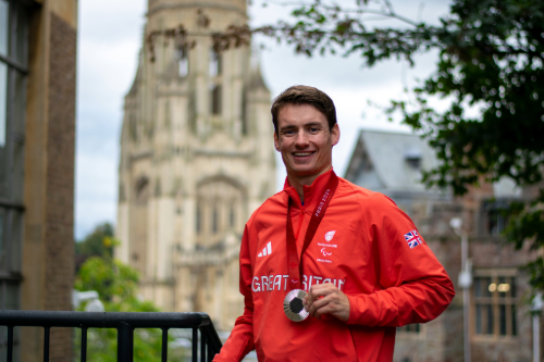 Law graduate Dan Bethell holds his medal in front of the University's Wills Memorial Building